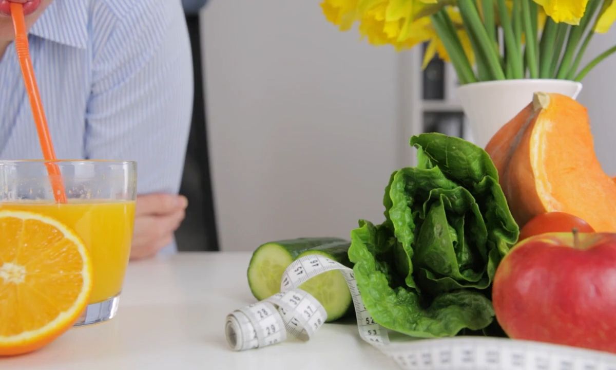 prikaz devojke koja pije sok od narandže, metar za merenje i povće u pozadini